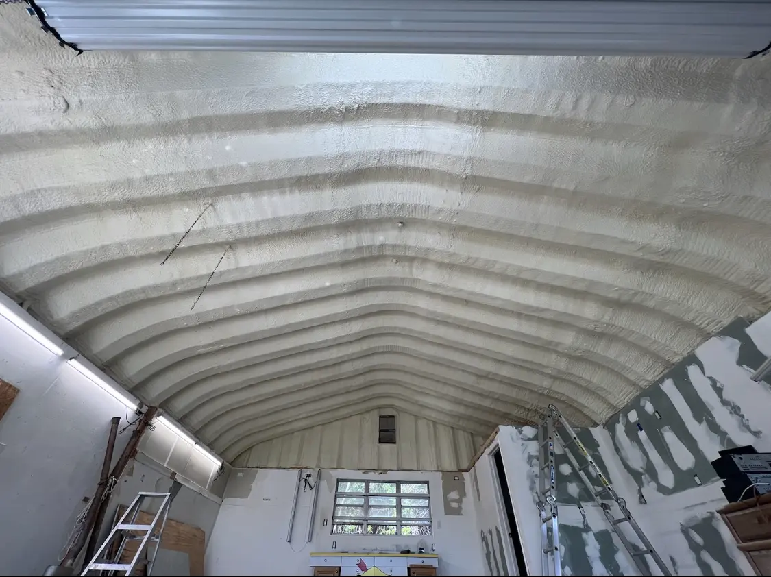 Spray polyurethane foam applied to the underside of a metal roof deck in Grimes